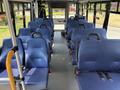 Interior of a 2020 Chevrolet Express bus featuring blue upholstered seats arranged in rows with seat belts attached