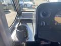 Interior view of a 2012 Ford Econoline showing the dashboard with a steering wheel gauge and a cup holder