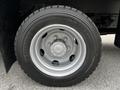 Close-up of a silver alloy wheel and tire from a 2014 Hino 195 featuring a Michelin tire and a detailed wheel hub design