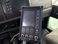 A control panel with a touchscreen interface featuring buttons for power, up, down, tank, and three auxiliary controls for a Kenworth T370 truck