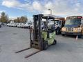 A 2000 Clark GPS 15 forklift in green and black with a raised fork positioned on a gravel surface