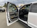 A 2018 Ford F-150 with its driver's side door open showcasing the interior features including the dashboard and seating area