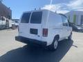 A white 2009 Ford Econoline van with a high roof and cargo space visible at the rear