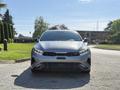 A 2024 Kia Forte5 viewed from the front showcasing its sleek design and sporty features with a prominent grille and bold headlights