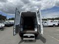 A 2016 Mercedes-Benz Sprinter van with double rear doors open showing an empty cargo area and a step at the rear