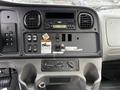 Interior dashboard of a 2005 Freightliner M2 106 featuring radio controls buttons and various function switches
