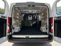 A 2023 Ford Transit with an empty cargo space featuring wooden slats along the walls and a partition at the back