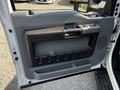 The interior door panel of a 2016 Ford F-550 featuring a handle button controls and storage compartments