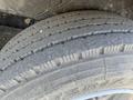 Close-up of a worn tire with visible tread patterns and cracks on the surface