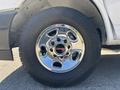 Close-up of a chrome wheel with a GMC logo and tire tread of a 2019 GMC Savana