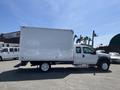 A 2008 Ford F-450 Super Duty with a white box truck body is parked on a paved surface with a plain side view visible