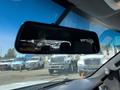 A 2014 Ford F-150's rearview mirror reflecting vehicles in the background