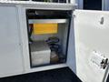 A 2016 Ford F-550 with an open storage compartment revealing a yellow battery and various electrical components inside