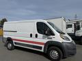A 2017 RAM Promaster van with a white exterior and a red stripe running along the side parked on a street