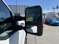 A side mirror of a 2014 Ford F-250 SD showing a clear reflection with a square shape and an orange turn signal indicator