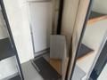 A 2004 Ford Econoline interior featuring a wooden step, gray paneling, and a partially visible wall with an empty space for a door