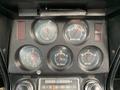 The dashboard of a 1972 Chevrolet Corvette featuring several round gauges for fuel, water temperature, oil pressure, and battery levels