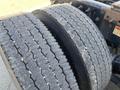 Close-up of a set of truck tires on a 2022 Freightliner Cascadia showing distinct tread patterns and signs of wear