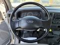 The interior of a 2008 Ford F-750 features a steering wheel with the Ford emblem and a dashboard displaying various gauges and controls