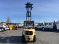 A 1993 Hyster H80XL forklift with a worn yellow exterior and black forks raised prominently in the air