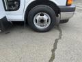 A flat tire on a 2017 Chevrolet Express van with a silver wheel rim and black tire visible in the foreground