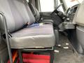 Interior view of a 2014 International Durastar truck showing the driver's seat and a row of passenger seats with black fabric upholstery and a simple dashboard setup