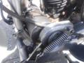 Close-up of a 1947 Harley-Davidson WL engine featuring exposed mechanical components such as the starter and various metal springs and rods