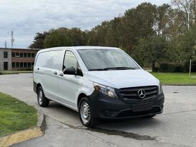 A 2019 Mercedes-Benz Metris with a white body and black front end parked on a paved area