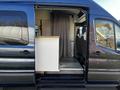 A 2017 Ford Transit van with an open sliding door revealing an interior that includes a small counter and seating area