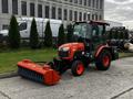 A 2018 Kubota B2650 compact tractor with a cab and snowblower attachment parked on a concrete surface