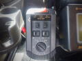 A control panel with various buttons and a large dial labeled MASTER AUTO and UNLOAD on a black surface