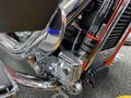 Close-up of a chrome engine component on a 2024 Harley Davidson Fat Boy motorcycle featuring detailed pipes and a visible air filter