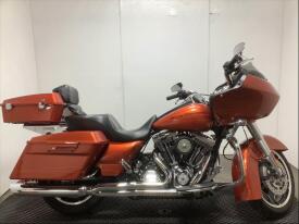 A 2011 Harley-Davidson FLTRX motorcycle in orange with a large front fairing saddlebags and a comfortable seat