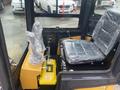 Interior view of a 2024 AGT Industrial H13R Mini Excavator showing the operator's seat control levers and a yellow control box