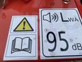 A close-up of warning and sound level labels on a piece of equipment featuring a caution symbol a book icon and a sound level indicator showing 95 dB