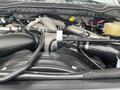 Close-up view of the engine compartment of a 2021 Ford F-550 showcasing various engine components and tubing