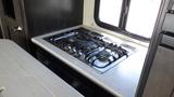 A gas stove with five burners in the kitchen of a 2021 Grand Design Recreational 311BHS