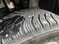 Close-up of a rugged tire with deep treads and visible winter studs on a 2021 RAM Promaster