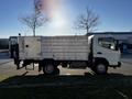 A 2014 Mitsubishi Fuso FE truck with a silver cargo bed and a black rear lift gate