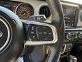 A close-up view of a 2021 Jeep Gladiator's steering wheel with control buttons for cruise control and audio functions