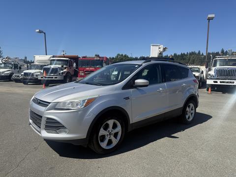 A silver 2014 Ford Escape parked with a modern design and five-spoke wheels, showcasing an SUV silhouette and distinctive front grille