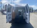 A 2009 Ford Econoline van with open rear doors showcasing its interior space filled with shelves and a desk
