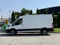 A white 2022 Ford Transit van with a sleek design parked in profile view showcasing its spacious cargo area and black accents on the lower body
