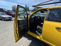 A yellow 2015 RAM 1500 with an open driver’s door revealing the interior dashboard and steering wheel