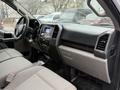 The interior of a 2018 Ford F-150 featuring gray fabric seats a central dashboard with a touchscreen display and air conditioning vents