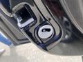 A close-up of the door latch mechanism of a 2015 Kia Sorento showing a circular keyhole with directional markings and a latch release button