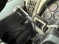 A close-up of a turn signal lever in a 2011 International 4300 featuring various indicators and controls for lights and wipers