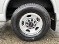 The wheel of a 2023 GMC Savana featuring a white rim with the GMC logo in the center and a Michelin tire with visible tread pattern