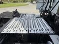A metallic and perforated truck bed of a 2012 Volvo VNL with visible components like connections and mechanical parts