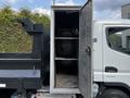 A 2015 Mitsubishi Fuso FE with an open storage compartment revealing shelves inside